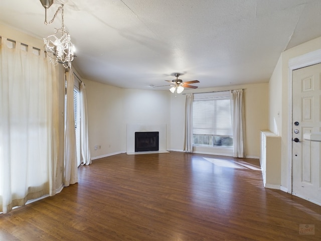 2450 Wickersham Ln Unit 702, Austin, TX 78741 - unfurnished living room with wood finished floors, a ceiling fan, a fireplace with flush hearth, baseboards, and a chandelier