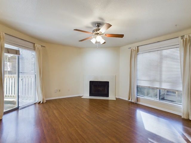 2450 Wickersham Ln Unit 702, Austin, TX 78741 - unfurnished living room with wood finished floors, ceiling fan, baseboards, and a fireplace with flush hearth