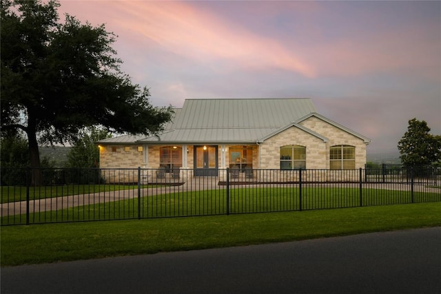 view of front facade featuring stone siding, a standing seam roof, and metal roof