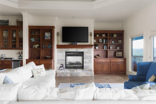 living room with crown molding, a stone fireplace, and light tile patterned floors