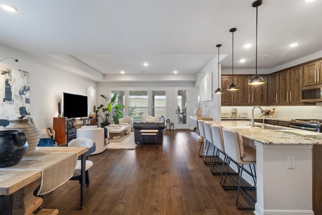 5333 Corelli Fls, Round Rock, TX 78665 - kitchen featuring stainless steel microwave, open floor plan, a sink, a kitchen bar, and recessed lighting