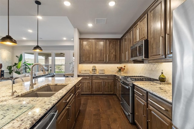 5333 Corelli Fls, Round Rock, TX 78665 - kitchen with appliances with stainless steel finishes, a sink, dark wood finished floors, light stone counters, and recessed lighting