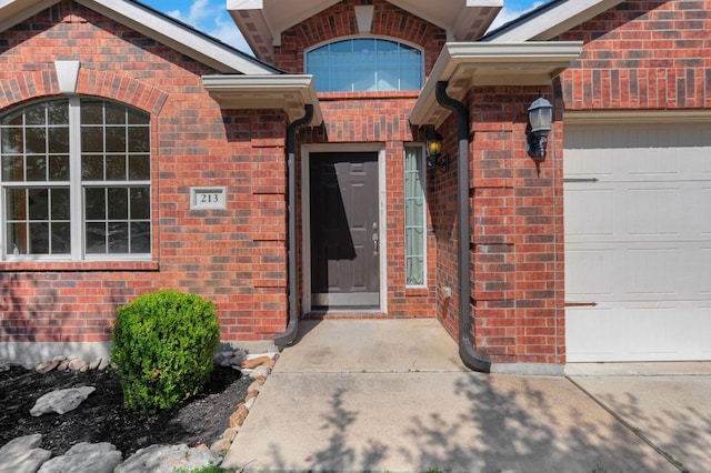 213 Sapphire Ln, Jarrell, TX 76537 - doorway to property with a garage and brick siding