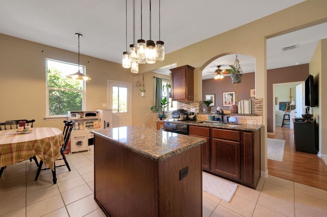 213 Sapphire Ln, Jarrell, TX 76537 - kitchen with a sink, dishwasher, a kitchen island, and light tile patterned floors