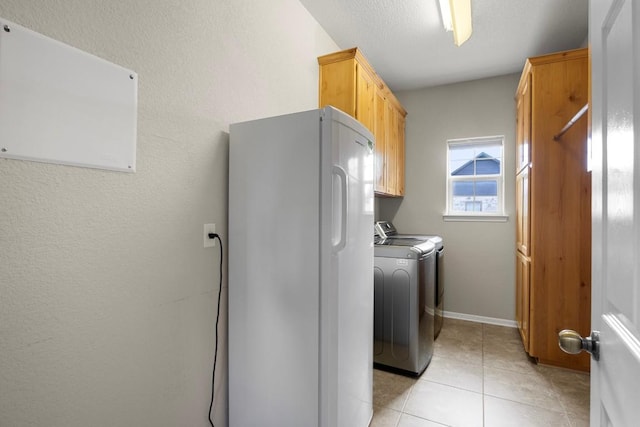 3585 W Amity Rd, Salado, TX 76571 - laundry room with cabinet space, separate washer and dryer, light tile patterned floors, and baseboards