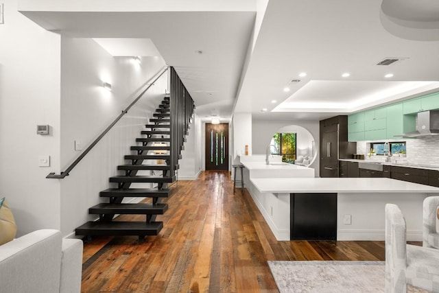 1705 Collier St, Austin, TX 78704 - kitchen with dark wood finished floors, light countertops, wall chimney range hood, a raised ceiling, and recessed lighting