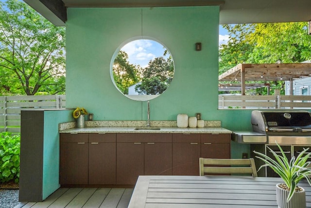 view of patio / terrace with a sink and fence