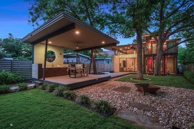 exterior space featuring a ceiling fan, a wooden deck, and stucco siding