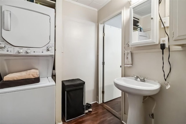300 Bishop St, Smithville, TX 78957 - bathroom with stacked washing machine and dryer, wood finished floors, crown molding, and baseboards