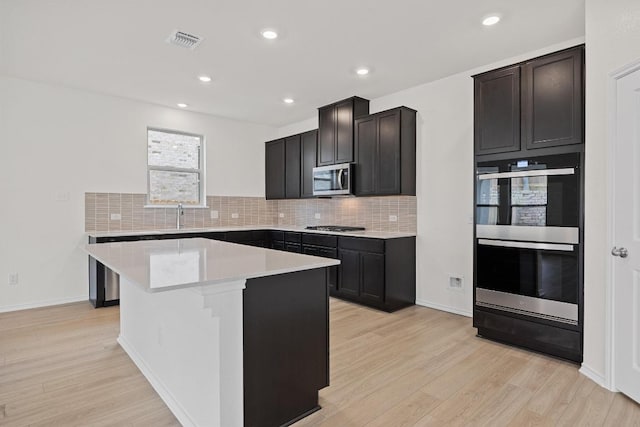 3740 Liberi Ln, Round Rock, TX 78655 - kitchen with appliances with stainless steel finishes, light wood-style flooring, decorative backsplash, and recessed lighting