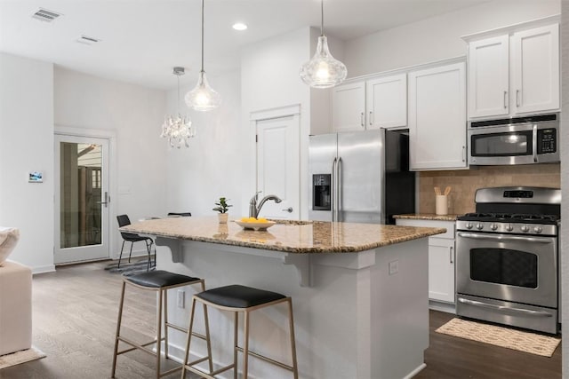 4108 Berkman Dr, Austin, TX 78723 - kitchen with appliances with stainless steel finishes, dark wood-style floors, a sink, light stone counters, and white cabinetry