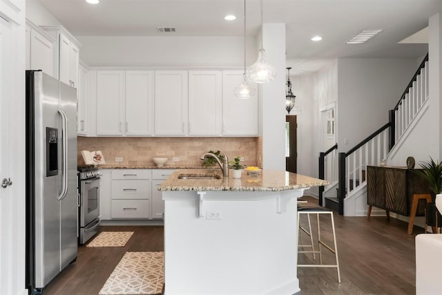 4108 Berkman Dr, Austin, TX 78723 - kitchen with appliances with stainless steel finishes, a sink, light stone countertops, a kitchen breakfast bar, and white cabinetry