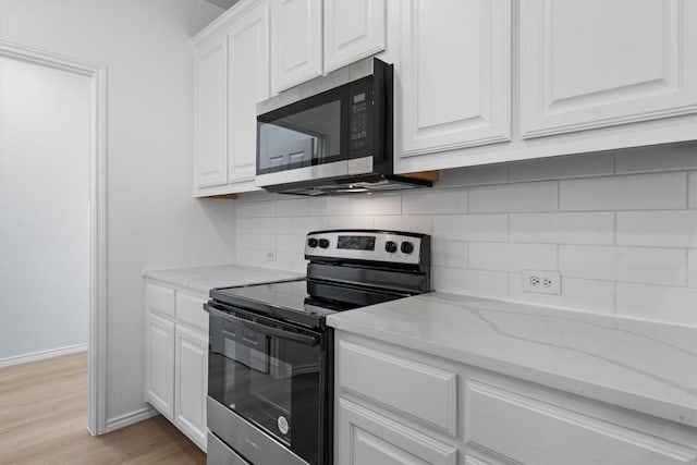 1816 Melissa Oaks Ln, Austin, TX 78744 - kitchen with appliances with stainless steel finishes, backsplash, white cabinets, light stone countertops, and light wood-type flooring
