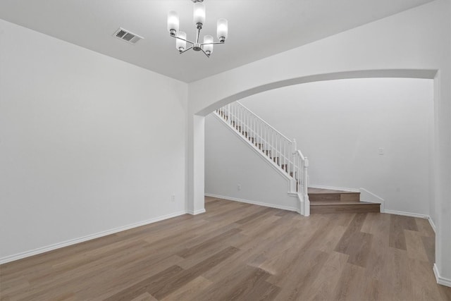 1816 Melissa Oaks Ln, Austin, TX 78744 - staircase with arched walkways, wood finished floors, a chandelier, and baseboards