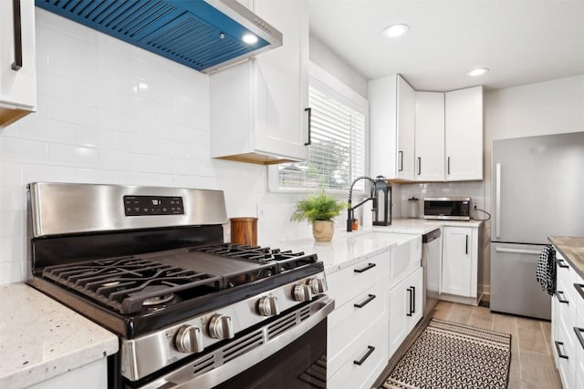 5530 US Highway 90a W, Shiner, TX 77984 - kitchen with appliances with stainless steel finishes, custom range hood, decorative backsplash, white cabinets, and recessed lighting