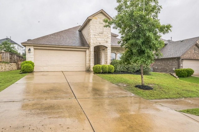 view of front of property featuring a garage, stone siding, driveway, and roof with shingles