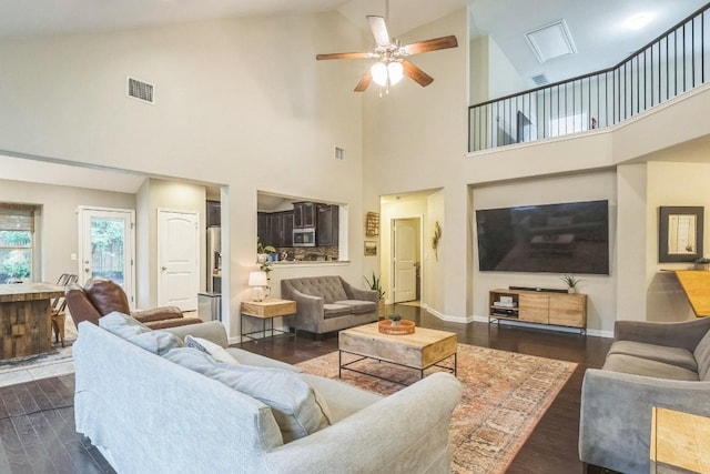 living area featuring dark wood finished floors, high vaulted ceiling, a ceiling fan, and baseboards