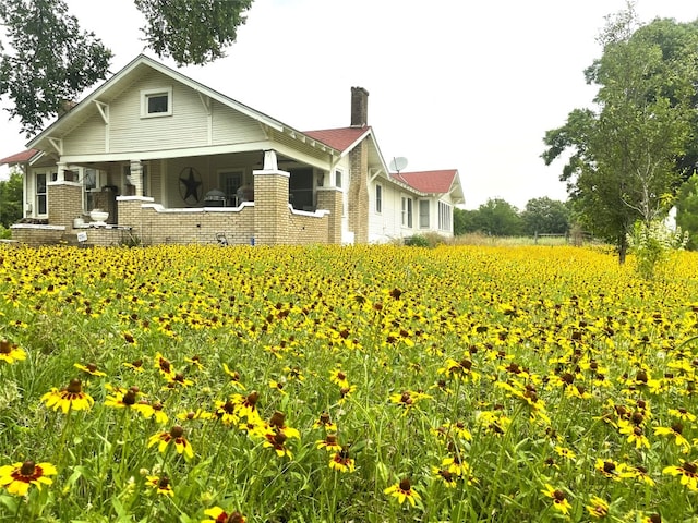 205 Sixth St, Mexia, TX 76686 - back of property with a chimney, agricultural area, brick siding, and a porch