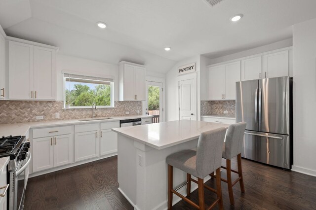 2324 Sawdust Dr, Georgetown, TX 78633 - kitchen with appliances with stainless steel finishes, a sink, white cabinetry, lofted ceiling, and recessed lighting