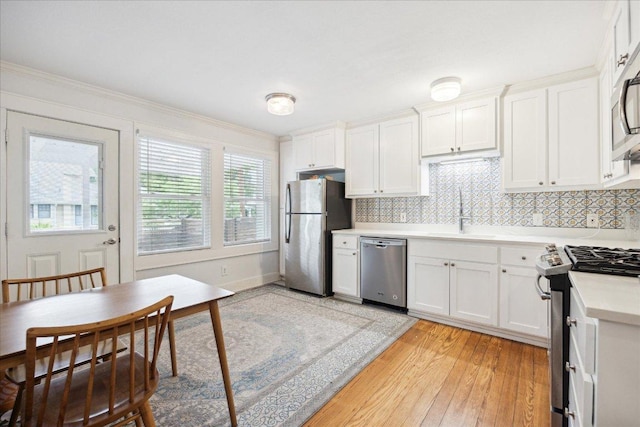 400 E 34th St, Austin, TX 78705 - kitchen featuring stainless steel appliances, a sink, light countertops, light wood-type flooring, and white cabinets