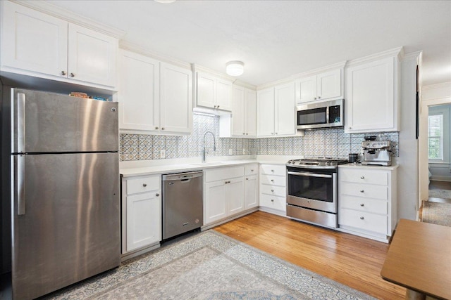400 E 34th St, Austin, TX 78705 - kitchen featuring stainless steel appliances, a sink, light countertops, white cabinets, and tasteful backsplash