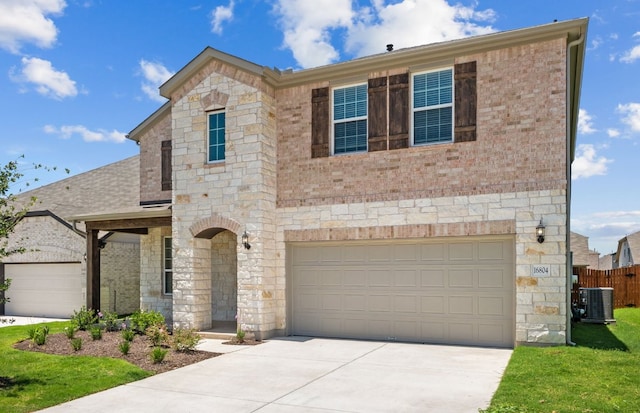16804 Santiaguillo Trce, Manor, TX 78653 - view of front facade with stone siding, concrete driveway, a garage, and brick siding