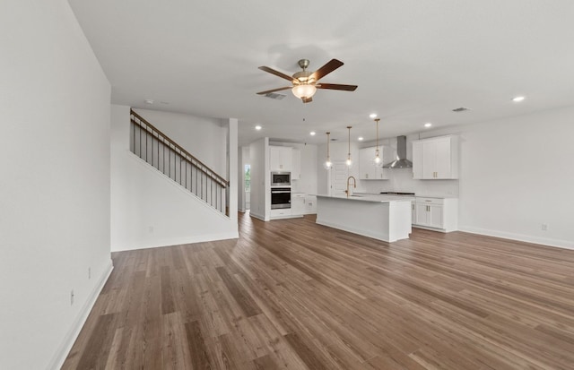 16804 Santiaguillo Trce, Manor, TX 78653 - unfurnished living room featuring a ceiling fan, recessed lighting, stairs, and wood finished floors
