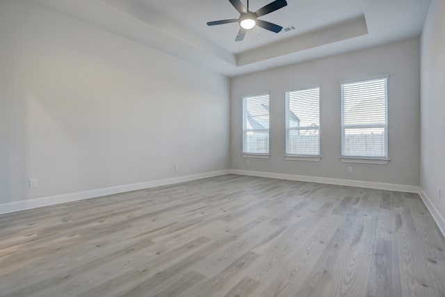 17212 Autumn Falls Dr, Manor, TX 78653 - unfurnished room featuring a tray ceiling, light wood finished floors, ceiling fan, and baseboards