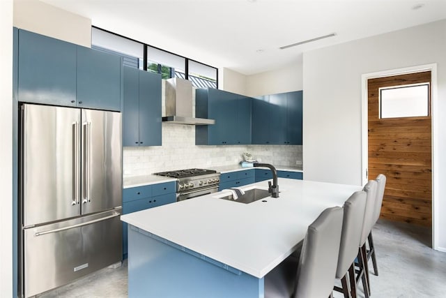 404 W Milton St, Austin, TX 78704 - kitchen with high quality appliances, blue cabinetry, a sink, finished concrete flooring, and wall chimney exhaust hood