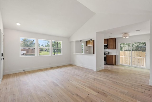 1800 Nicole Cir, Round Rock, TX 78664 - unfurnished living room featuring healthy amount of natural light, light wood finished floors, baseboards, a sink, and high vaulted ceiling
