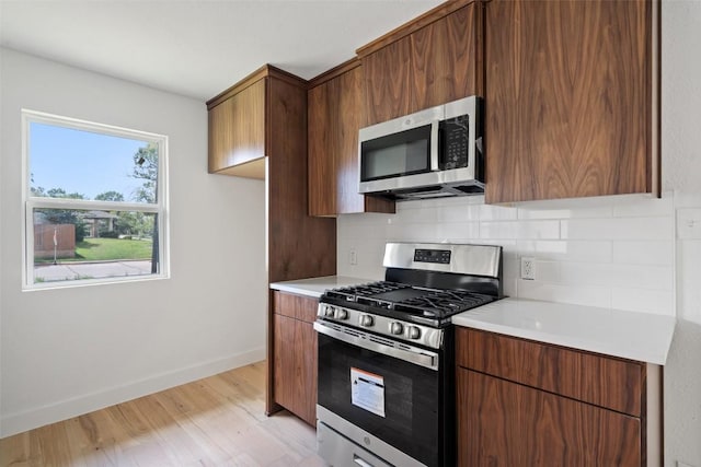 1800 Nicole Cir, Round Rock, TX 78664 - kitchen with appliances with stainless steel finishes, decorative backsplash, baseboards, light countertops, and light wood-style flooring
