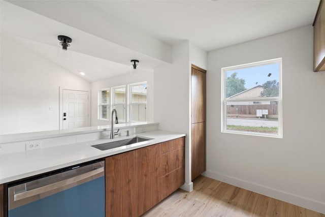 1800 Nicole Cir, Round Rock, TX 78664 - kitchen featuring dishwasher, a sink, brown cabinets, baseboards, and light wood-type flooring