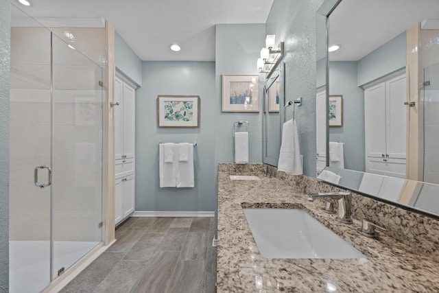 906 Texas Trl, Austin, TX 78737 - bathroom featuring a stall shower, double vanity, baseboards, and recessed lighting