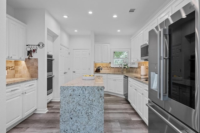 906 Texas Trl, Austin, TX 78737 - kitchen featuring stainless steel appliances, a sink, recessed lighting, white cabinets, and a kitchen island