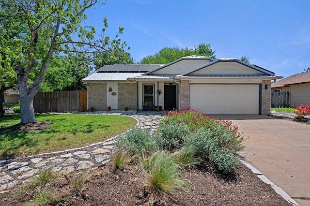 11707 Ruffed Grouse Dr, Austin, TX 78758 - single story home with an attached garage, brick siding, concrete driveway, and solar panels