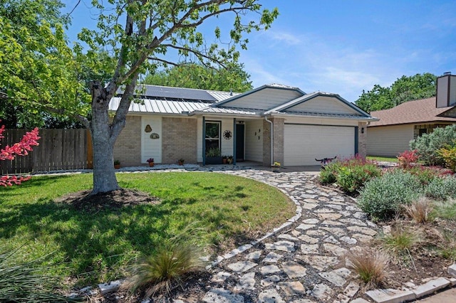 11707 Ruffed Grouse Dr, Austin, TX 78758 - single story home with brick siding, an attached garage, solar panels, a metal roof, and concrete driveway