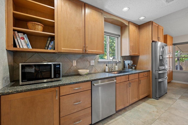 11707 Ruffed Grouse Dr, Austin, TX 78758 - kitchen with stainless steel appliances, tasteful backsplash, a textured ceiling, light tile patterned flooring, and dark stone counters