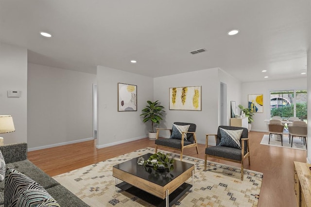 living area with light wood-style floors, recessed lighting, and baseboards