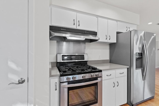 kitchen featuring appliances with stainless steel finishes, under cabinet range hood, light countertops, white cabinets, and light wood finished floors
