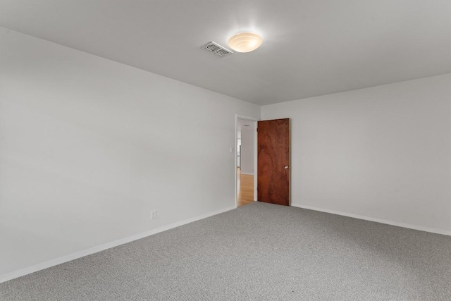 carpeted empty room featuring baseboards