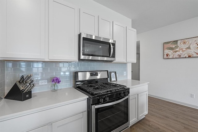 kitchen with stainless steel appliances, light countertops, backsplash, and white cabinetry