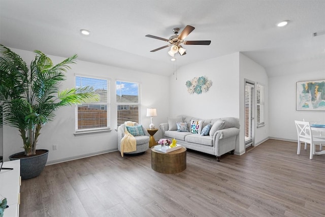 living room with wood finished floors, a ceiling fan, vaulted ceiling, baseboards, and recessed lighting