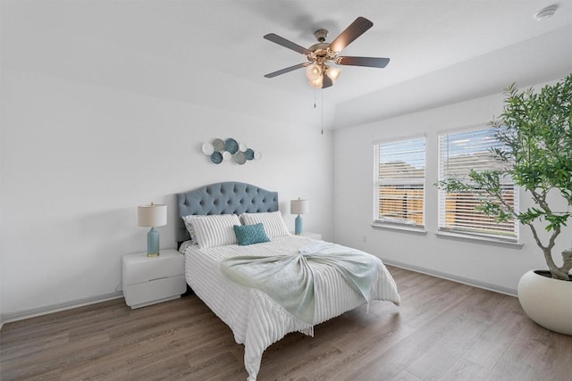 bedroom with wood finished floors, baseboards, and ceiling fan