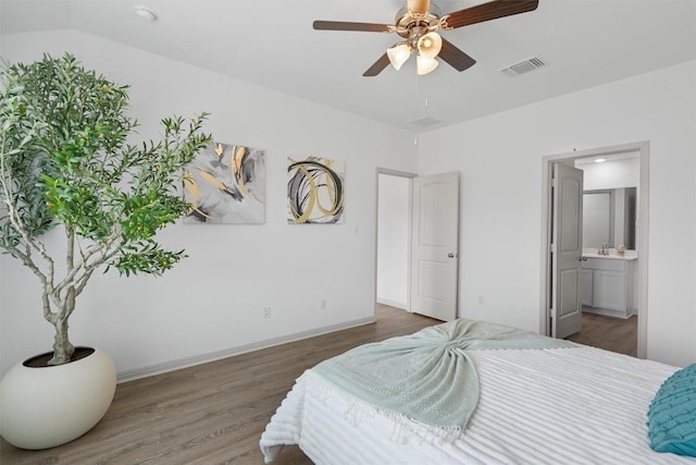 bedroom with wood finished floors, connected bathroom, and ceiling fan