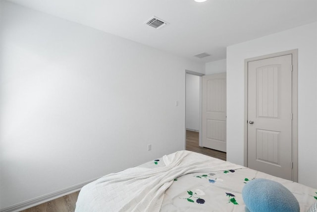 bedroom with dark wood finished floors and baseboards