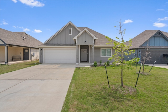 view of front of home with board and batten siding, an attached garage, driveway, and a front lawn