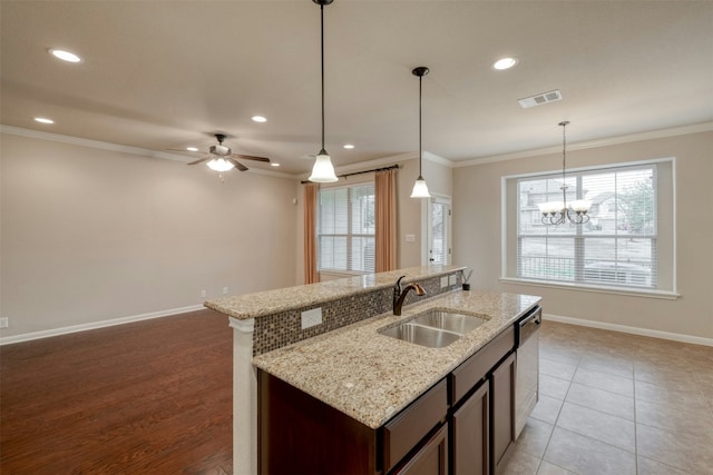 14001 Avery Ranch Blvd Unit 1103, Austin, TX 78717 - kitchen featuring a sink, ornamental molding, baseboards, an island with sink, and hanging light fixtures