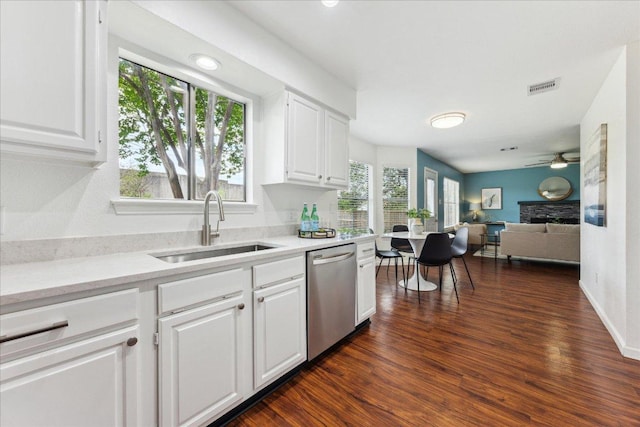 kitchen featuring dishwasher, a sink, a ceiling fan, white cabinets, and dark wood finished floors