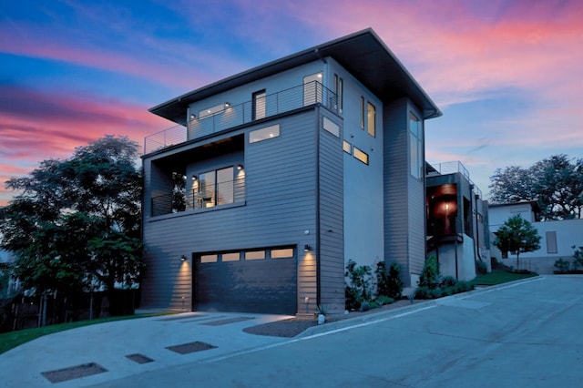 2800 Del Curto Rd Unit 9, Austin, TX 78704 - property exterior at dusk with a balcony, a garage, and asphalt driveway