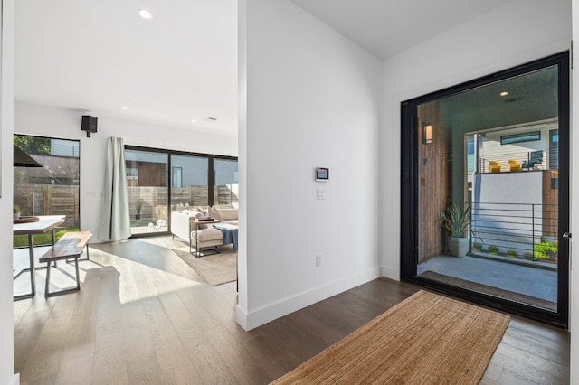 entryway with wood finished floors, baseboards, and recessed lighting